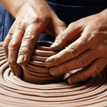 **Prompt 1: Authentic Hands, Speaking Clay**
    "A close-up, warm-toned photograph capturing a ceramist's hands deeply engaged in shaping clay using non-standard techniques. Emphasize the tactile connection, showcasing visible finger marks, organic coil building, or subtly joined slab construction. The focus should be on the raw, earthy texture of the clay, with hints of imprinted natural elements like leaves or subtle tooling marks. The scene conveys a sense of meditative creation, imperfect beauty, and the unique, soulful character emerging from the hands-on process. Soft, natural light highlights the material's inherent qualities, evoking a timeless, artisanal feel."